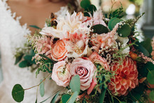 Bride Holds Rich Wedding Bouquet Made Of Orange And Red Autumn Flowers