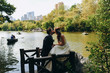 © IVASHstudio - Bride and groom kiss on the bench of a lake in the New York Central Park