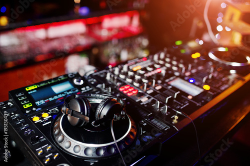 DJ spinning mixing and scratching track controls on dj's deck strobe Wallpaper Mural