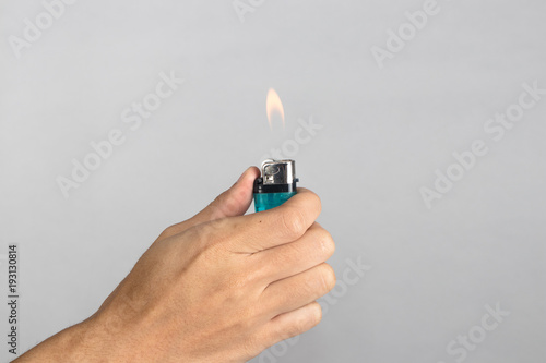 Cuadros en Lienzo Hand holds blue lighter in hand and pressing it