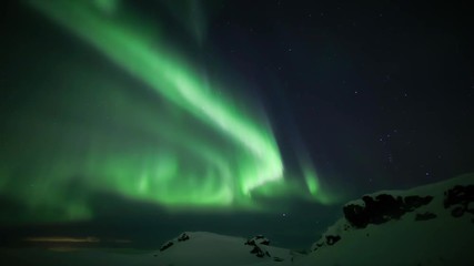 Wall Mural - brilliant snake like aurora borealis winding over snow covered rocky landscape, iceland 4k.mov