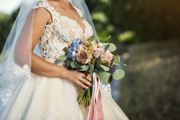 bouquet in hands of the bride, woman getting ready before wedding ceremony