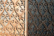 rusty old wrought iron gates half-illuminated by the sun