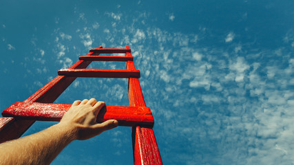 development attainment motivation career growth concept. mans hand reaching for red ladder leading t