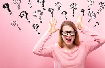 Question Marks with young woman feeling stressed on a pink background