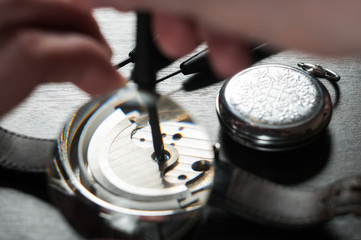 the watchmaker is repairing the old dirty clock