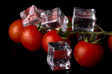 Wall Mural - Banch of red cherry tomatos and ice cubes on black wet table. Selective focus