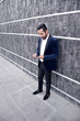 © Stef - young businessman in suit texting outside office