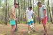 © auremar - three boys playing football in the forest