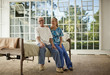 © Erickson Stock - Smiling senior man being comforted by a female nurse inside his bedroom.