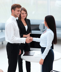 Sticker - business partners shaking hands while standing in the lobby of the office.