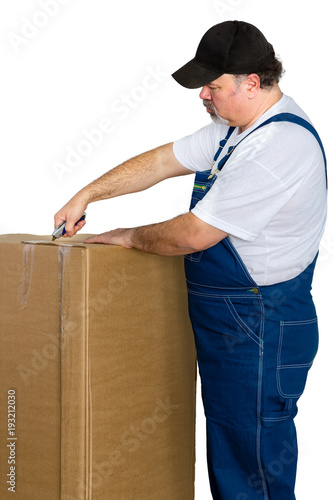 Fotografie, Obraz Man wearing dungarees opening large cardboard box