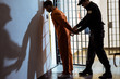 side view of prison officer wearing handcuffs on prisoner