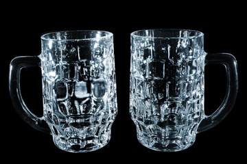 Two beer mugs isolated on black background