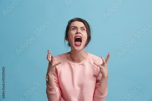 Fotografía The young emotional angry woman screaming on blue studio background