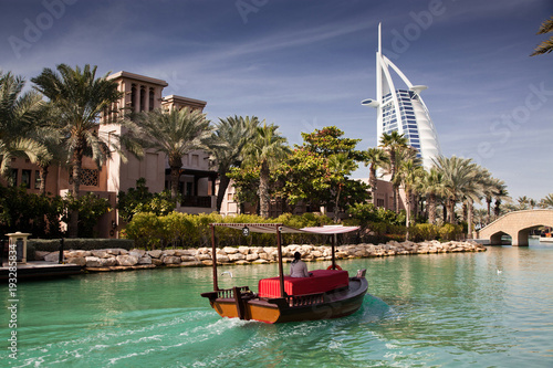Fotomural DUBAI, UAE - FEBRUARY, 2018: View on Burj Al Arab, the world only seven stars hotel seen from Madinat Jumeirah, a luxury resort which include hotels and souk spreding across over 40 hectars