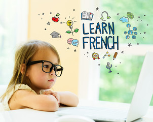 Wall Mural - Learn French text with little girl using her laptop