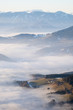 Hill looking through low stratus fog with mountain range Hochschwab