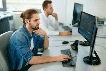 Programmers Working, Looking At Computer In IT Office.