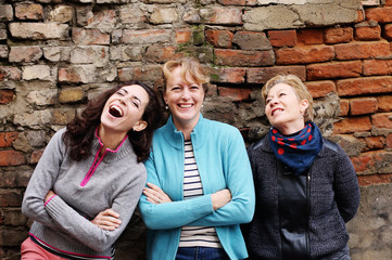 Sticker - Outdoor portrait of three women standing next to the vintage wall