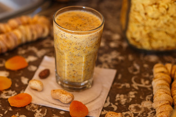 a glass of yellow smoothie with chia seeds