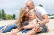 © sergo321 - Young family with a toddler resting on the beach.