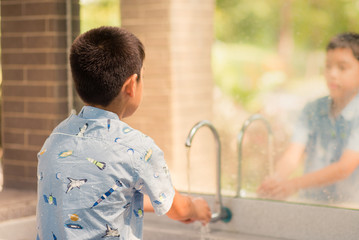 Wall Mural - Little boy washing his hand in the bath