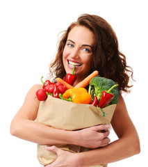 Young woman holding grocery paper shopping bag full of fresh vegetables. Diet healthy eating concept