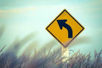 Winding road sign on blue sky