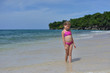 © Marina - Little blonde Caucasian girl is on the beach with gold sand and blue water somewhere in Caribbean.