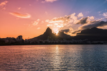 Sunset Over Mountains In Rio De Janeiro With Water Reflection And Light Leak, Brazil