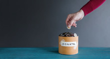 Donation Concept. Hand Putting Money Coin Into A Donate Box