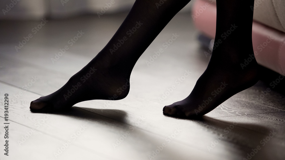 Elegant female legs in black tights on the floor, style and fashion, clothing - obrazy, fototapety, plakaty 
