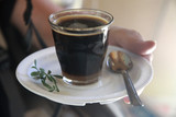 Fototapeta Mosty linowy / wiszący - kawa po etiopsku podana w małym szklanym naczyniu na białym porcelanowym spodku