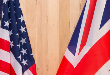 USA flag and UK Flag on wooden background light.