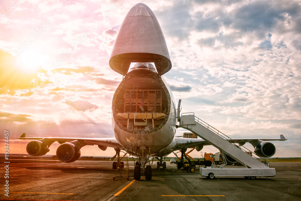 Unloading wide body transport cargo aircraft in the morning sun - obrazy, fototapety, plakaty 