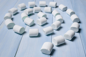 marshmallow on a blue board lined up in the form of a spiral, concept