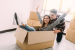 © F8  \ Suport Ukraine - Happy young couple is having fun with cardboard boxes in new house at moving day.