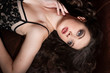 © Iulia - Fashion portrait of a woman in a tight black dress lying on a sofa