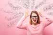Confused young woman feeling stressed on a pink background