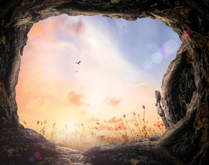 Wall Mural - resurrection of easter sunday concept: tomb stone and meadow autumn sunrise background