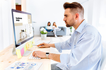 Hipster man interior design browsing e-magazine scandinavian design website