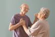 © Africa Studio - Cute elderly couple dancing against color background