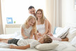 © Africa Studio - Happy family on bed with soft pillows at home