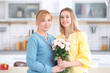 © Africa Studio - Young woman giving bouquet to her mother at home