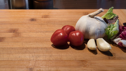 garlic and tomato on wooden board