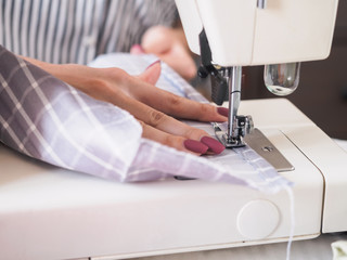 Girl working on sewing machine with textile napkins