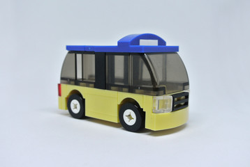 Selected focused of toy bus made from plastic brick and isolated on white background. 