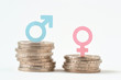 © calypso77 - Male and female symbols on piles of coins - Gender pay equality concept