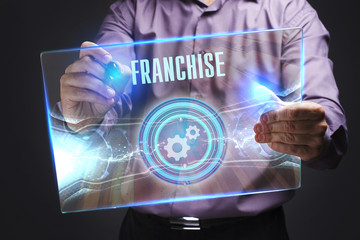 The concept of business, technology, the Internet and the network. A young entrepreneur working on a virtual screen of the future and sees the inscription: Franchise